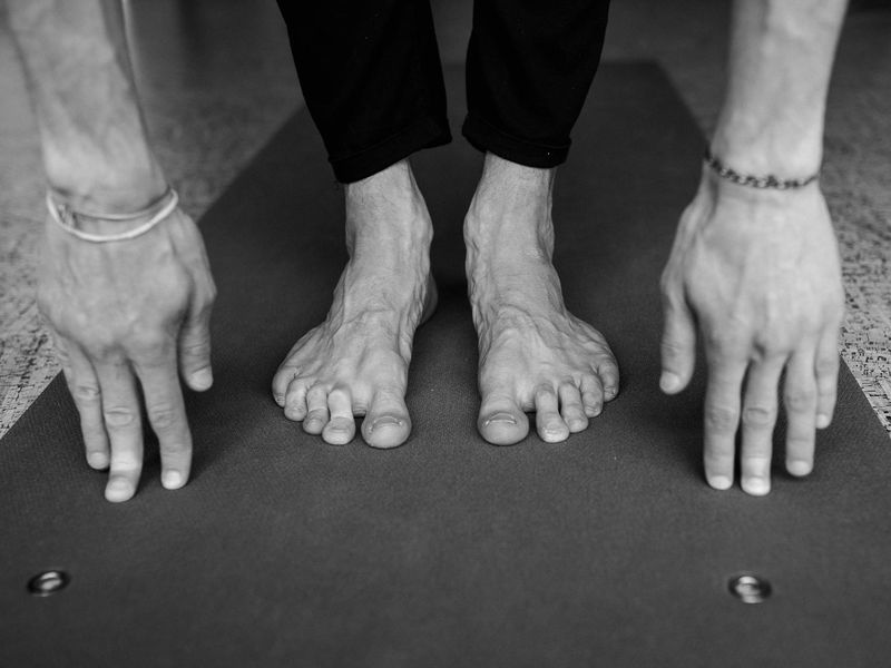 Close up of a controlled yoga movement on mat.